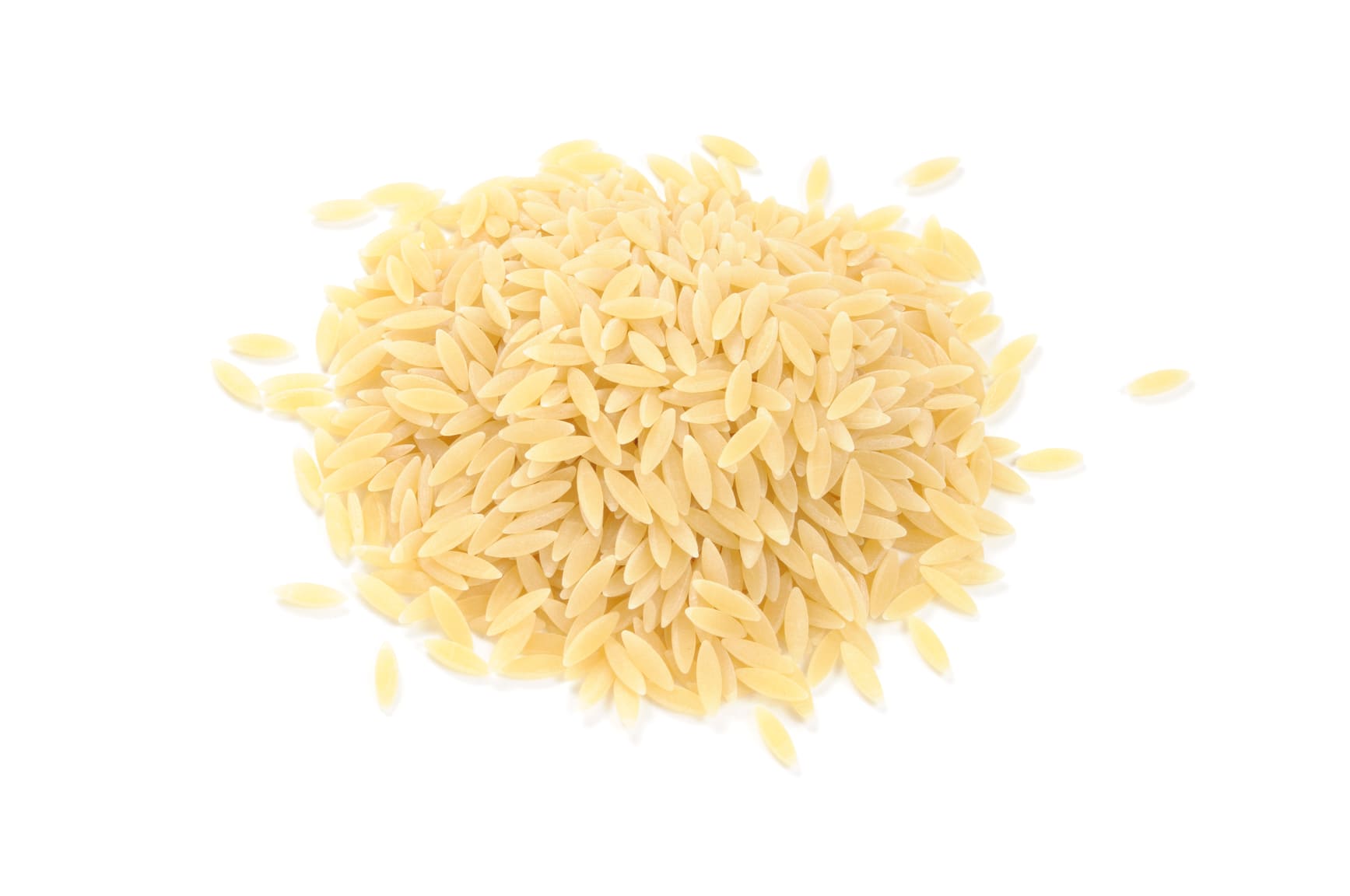 Pile of uncooked long-grain rice on a white background, pale beige color.
